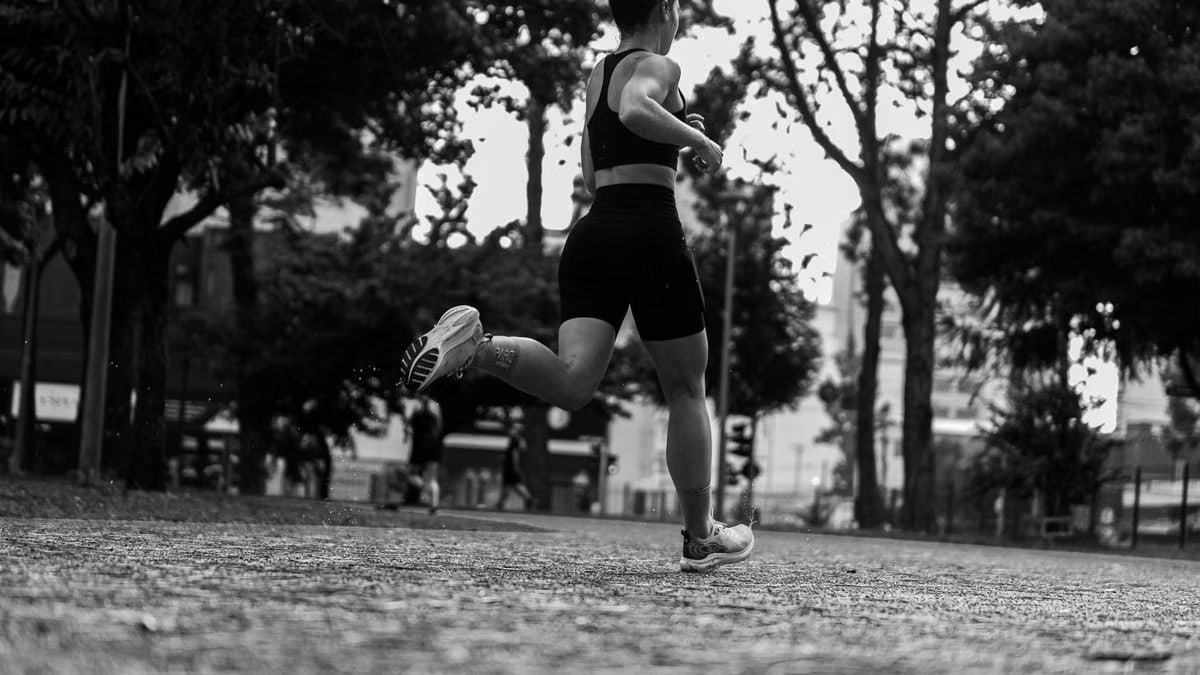 Dramatic black and white photo of a woman running through a park.
